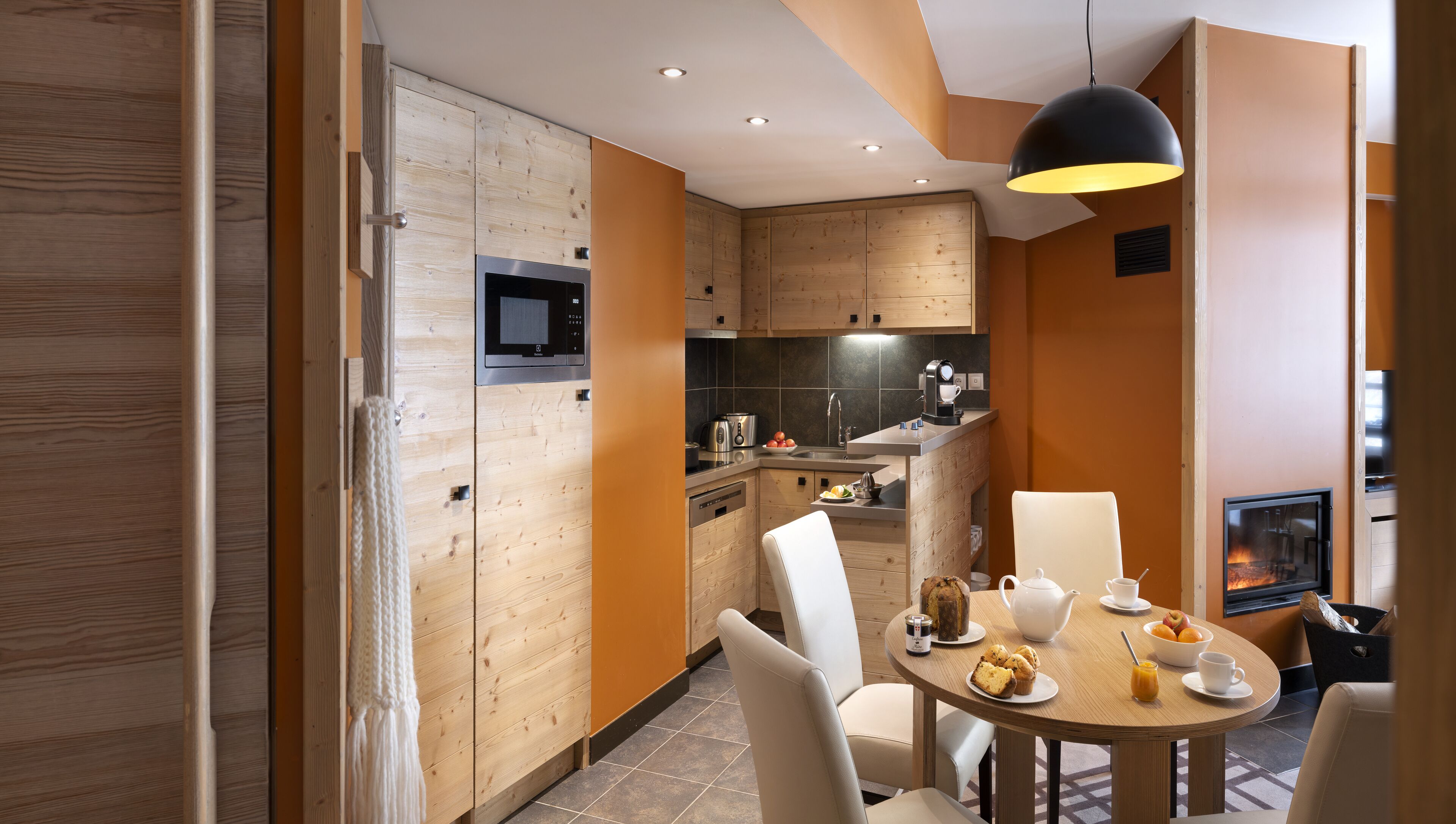 A modern kitchen with wooden cabinets, a built-in microwave, and a coffee machine.