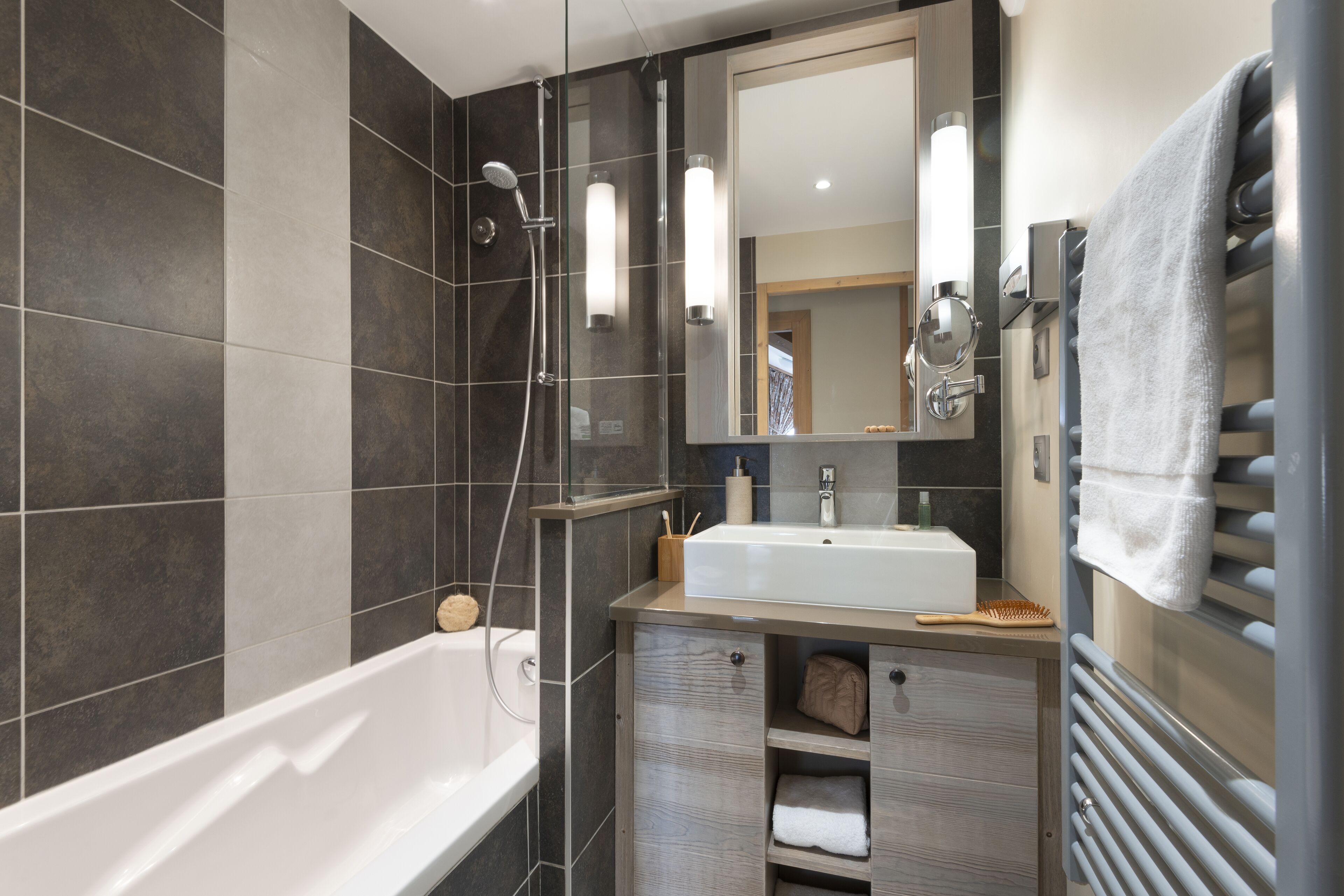 A modern bathroom with a bathtub, a sink, and a mirror.