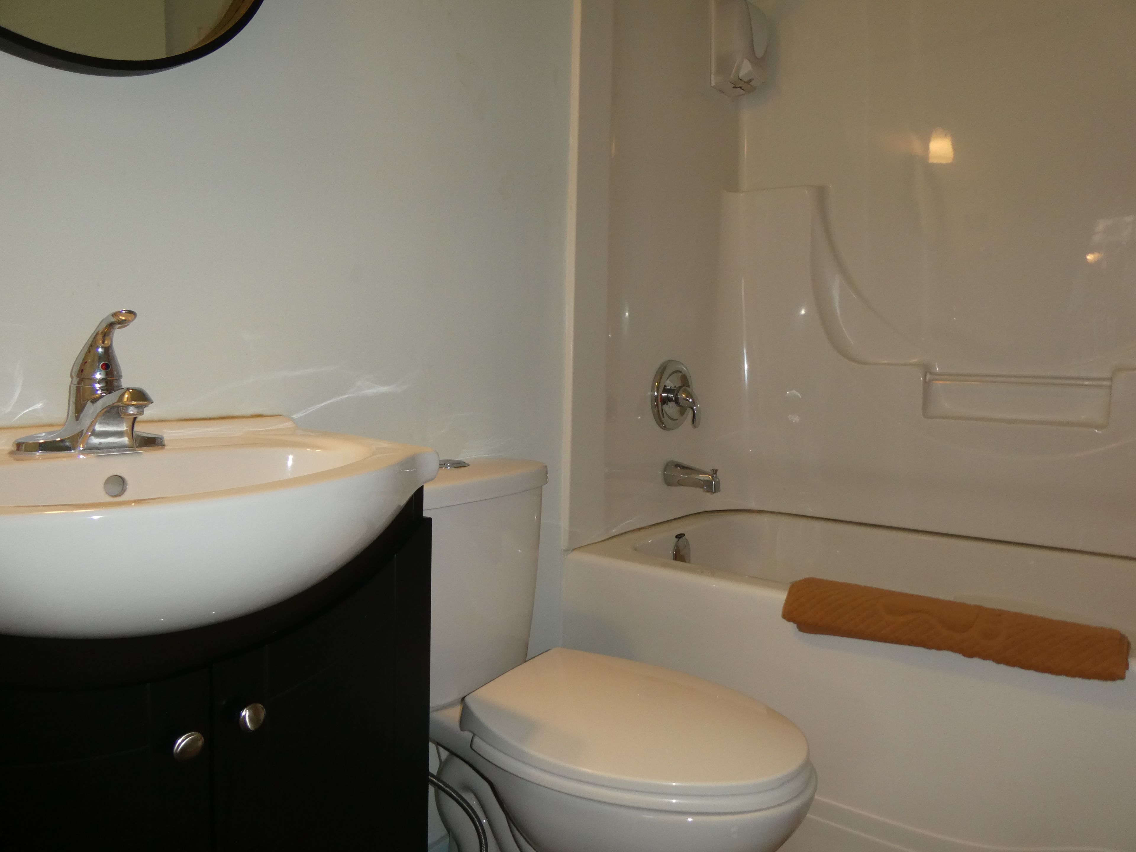Et badeværelse med vask, toilet og badekar.