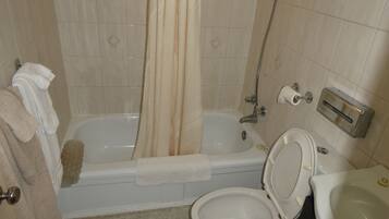Une salle de bain avec une baignoire, des toilettes et un lavabo.