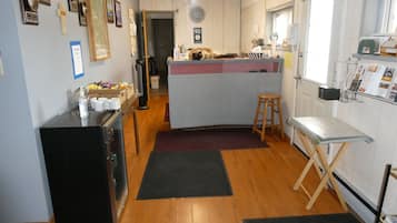 Una cocina con piso de madera, un refrigerador, un lavamanos y una ventana.