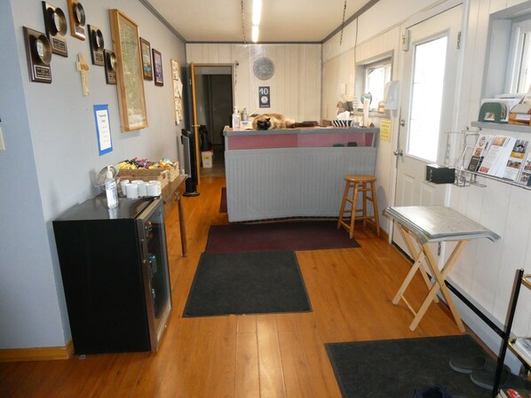 A kitchen with wooden flooring, a refrigerator, a sink, and a window. - Airport Inn Motel & RV Park (Quesnel)