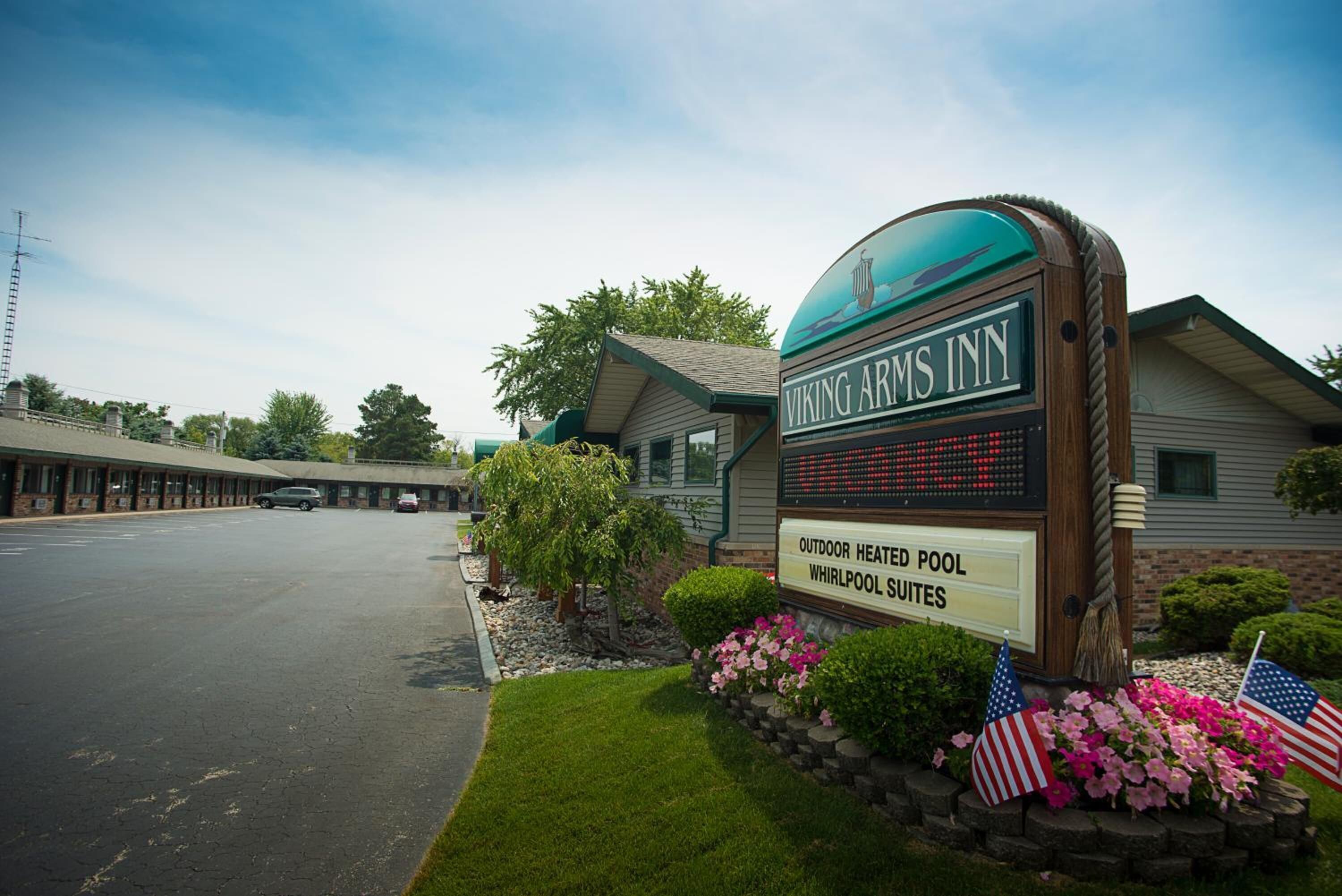 A motel sign with "Viking Arms Inn" and "Outdoor Heated Pool Whirlpool Suites" visible.