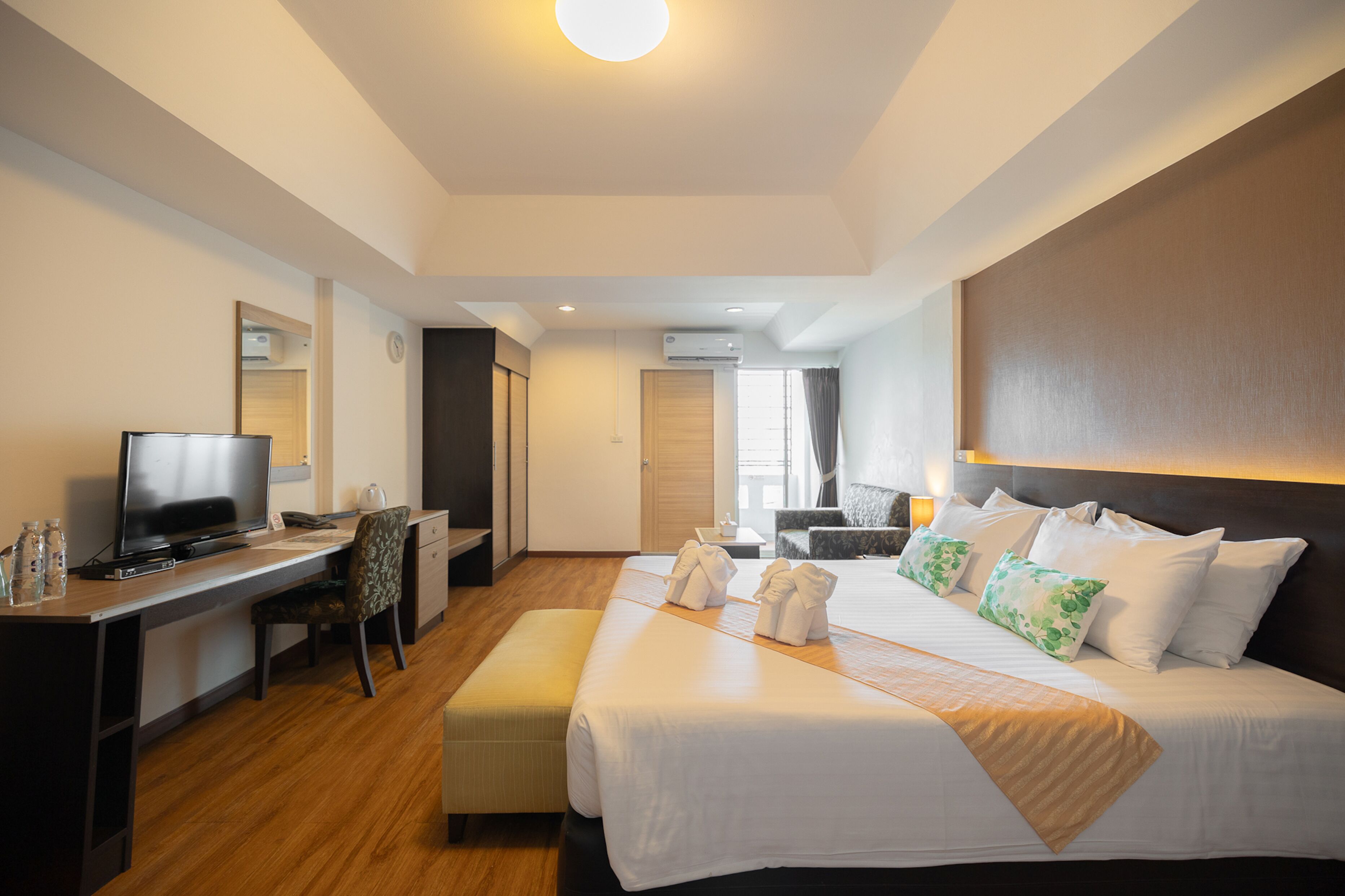 Une chambre d’hôtel équipée d’un lit, d’un bureau, d’une télévision et d’une chaise.