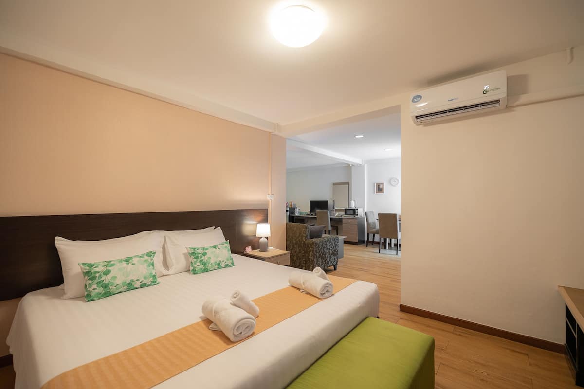 Hotellihuone, jossa on sänky, työpöytä ja ilmastointilaite.