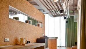 Una cocina moderna con encimera de madera, lavavajillas integrado y un amplio ventanal con cortinas.