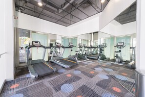 A gym with treadmills, mirrors, and a patterned carpet. - Y Loft Youth Square (Hong Kong)