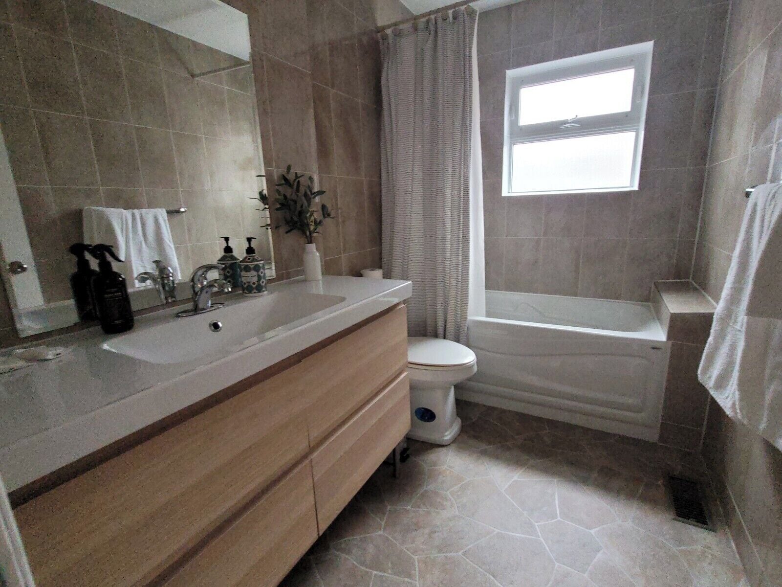 Un baño con lavamanos, inodoro y bañera.