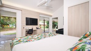 Ein modernes Schlafzimmer mit Bett, Schreibtisch und Fernseher.