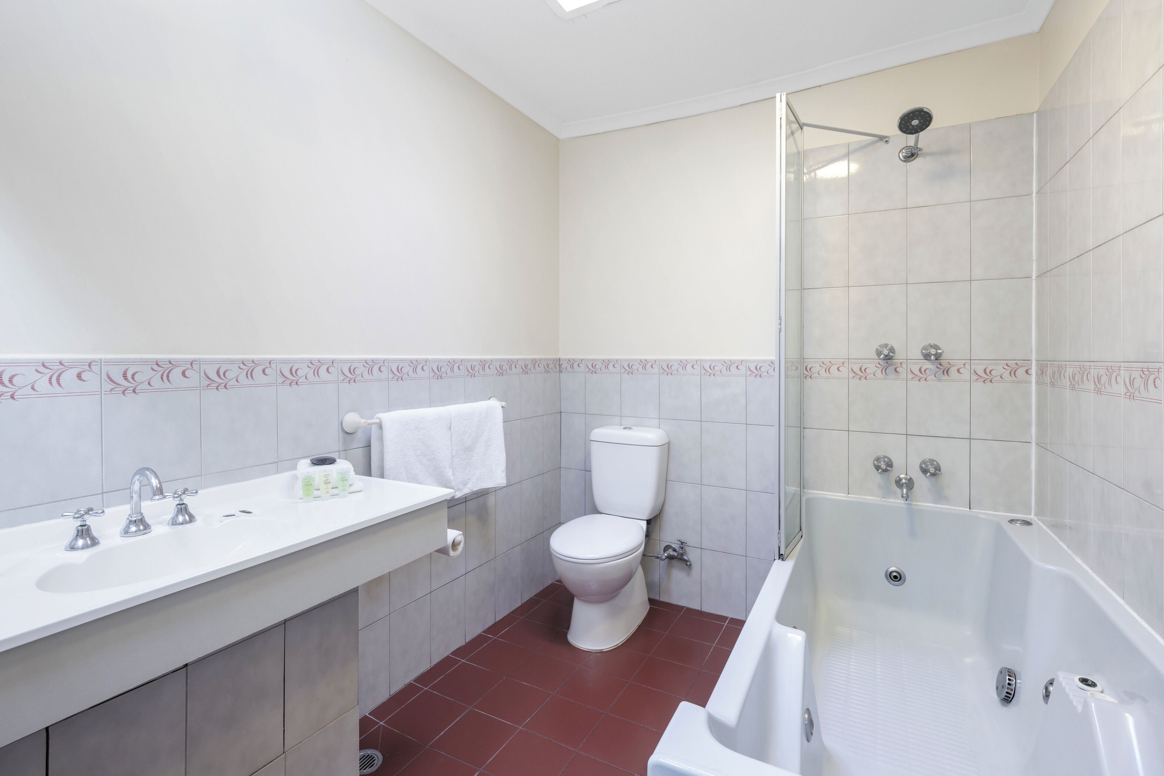 Une salle de bain avec des toilettes, un lavabo et une baignoire.