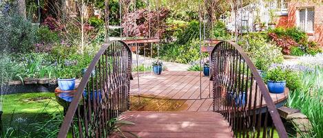 Un puente de madera con barandillas de metal en un jardín.