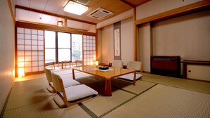 A traditional Japanese room with tatami flooring, a low wooden table, and shoji screens. - Hotel Pony Onsen (Towada)