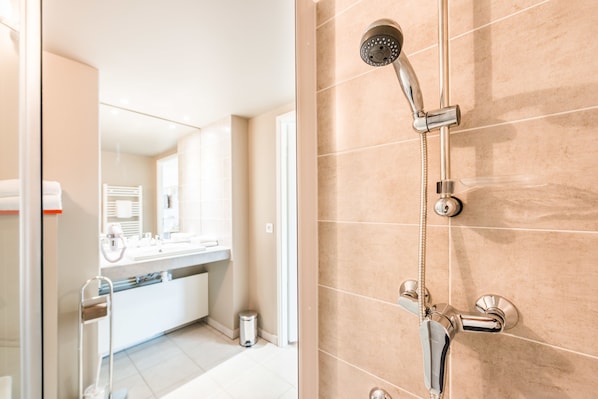 A modern bathroom with a shower, a sink, and a mirror.