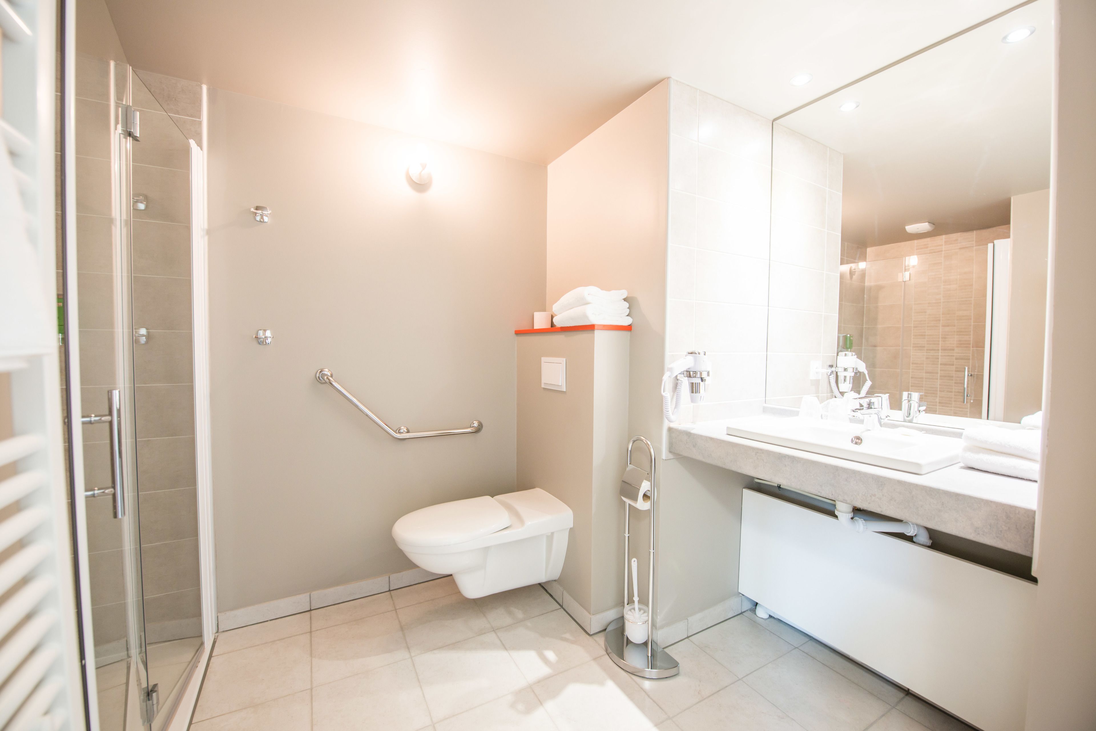 Un baño moderno con ducha, inodoro y lavabo.