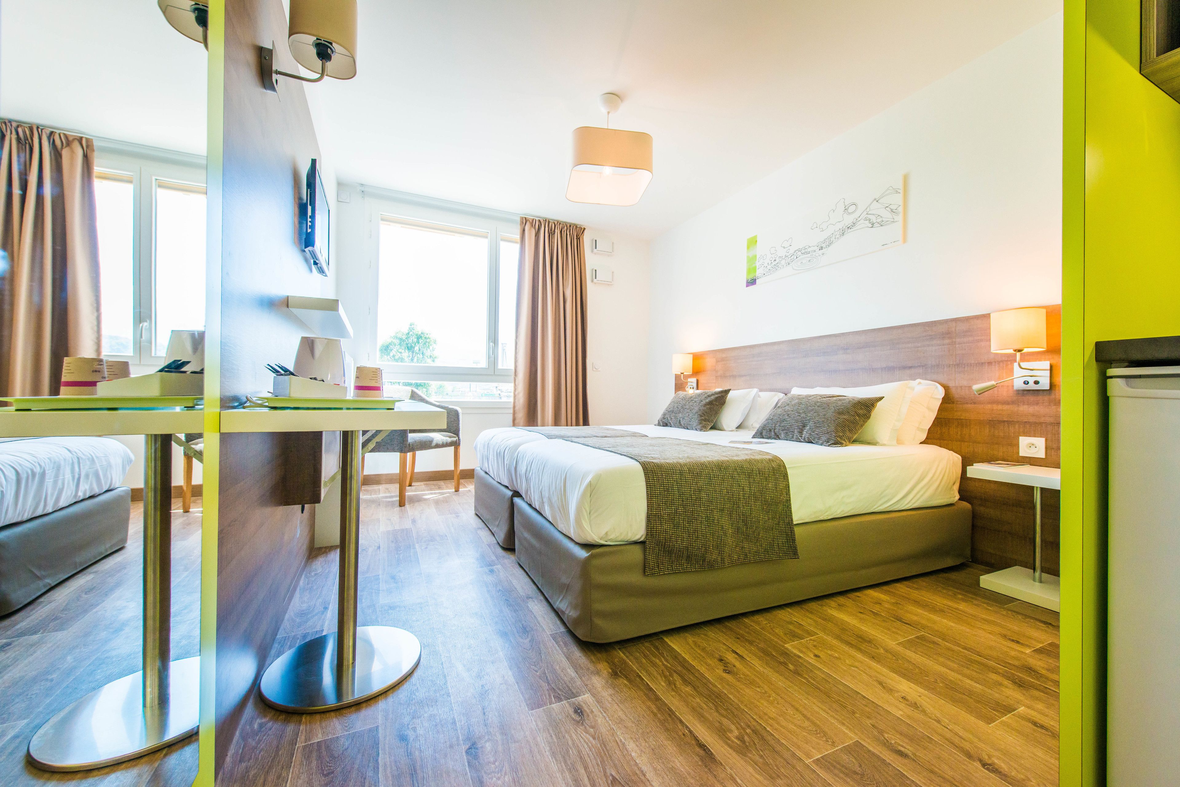 Een moderne hotelkamer met een bed, een bureau en een stoel.