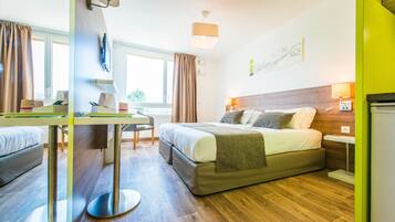 Een moderne hotelkamer met een bed, een bureau en een stoel.