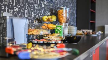 A buffet with various food items and a beverage dispenser.