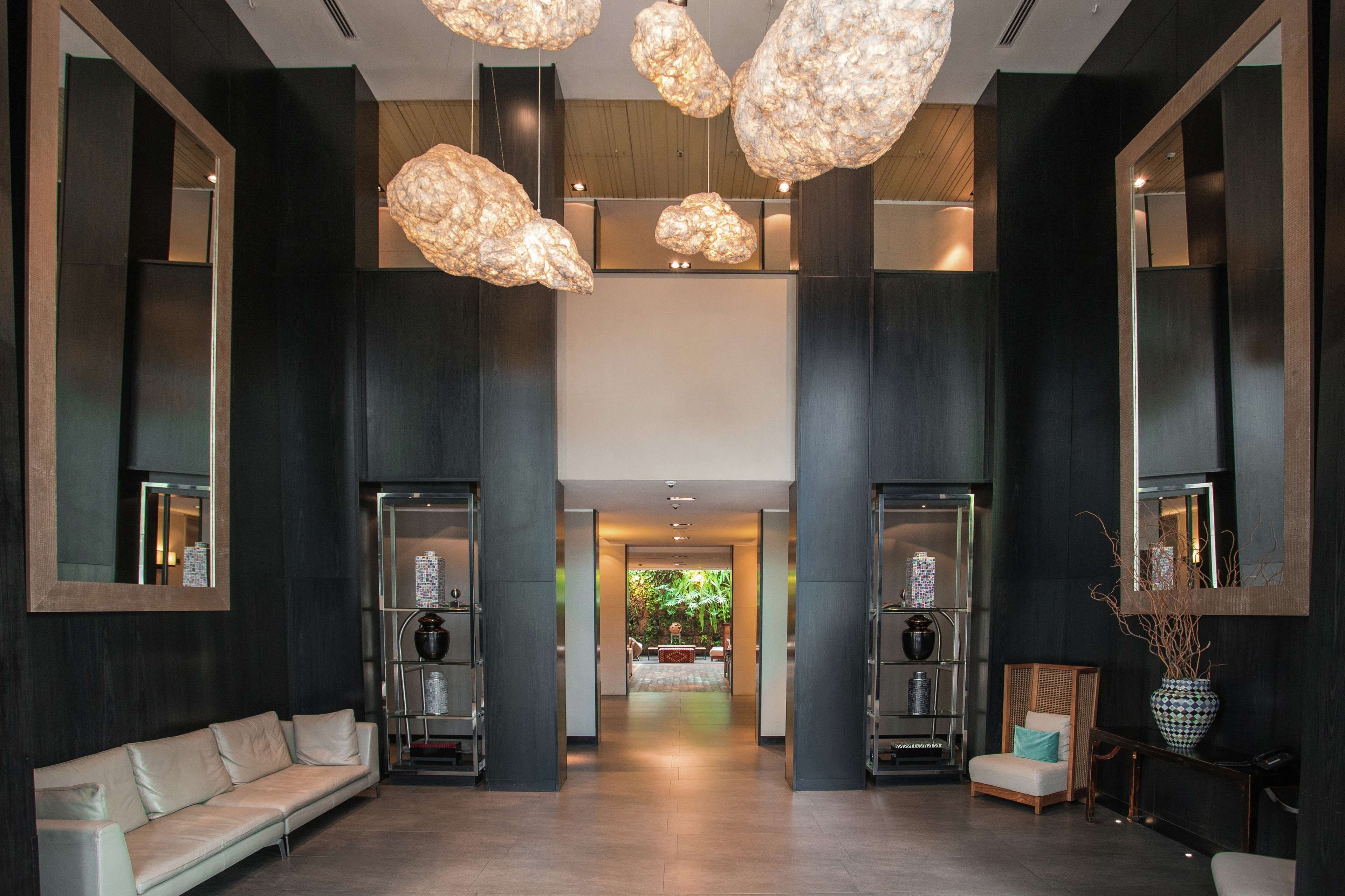 En moderne lobby med sofa, stol og vase.