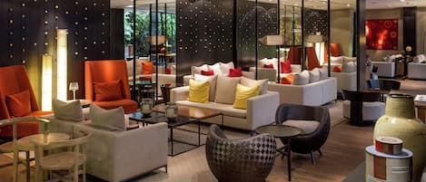A modern lounge area with sofas, armchairs, and a coffee table.