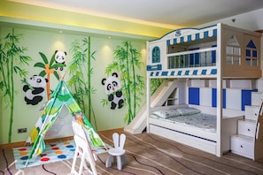 Habitación infantil con literas, una carpa de juegos y decoración de pared temática de pandas.