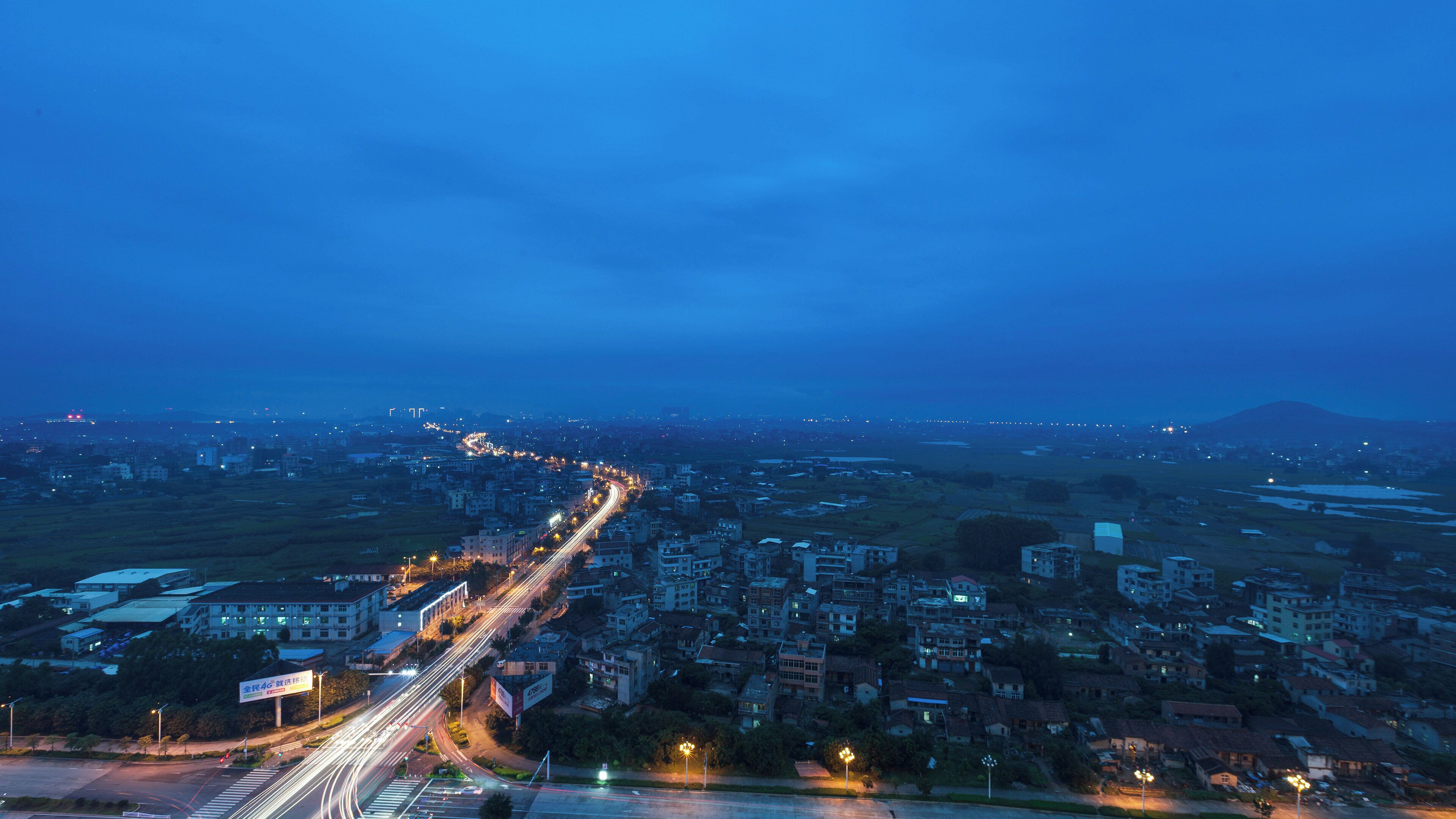 A nighttime cityscape with a highway and buildings.