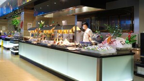 A buffet area with a variety of food items and a chef preparing food. - Holiday Inn Putian Xiuyu by IHG (Putian)