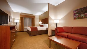 A hotel room with a bed, a sofa, a desk, and a TV. - Best Western Plus Finger Lakes Inn & Suites (Cortland)