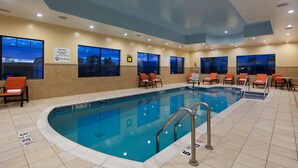 An indoor swimming pool with clear water, tiled floor, and multiple lounge chairs. - Best Western Plus Finger Lakes Inn & Suites (Cortland)