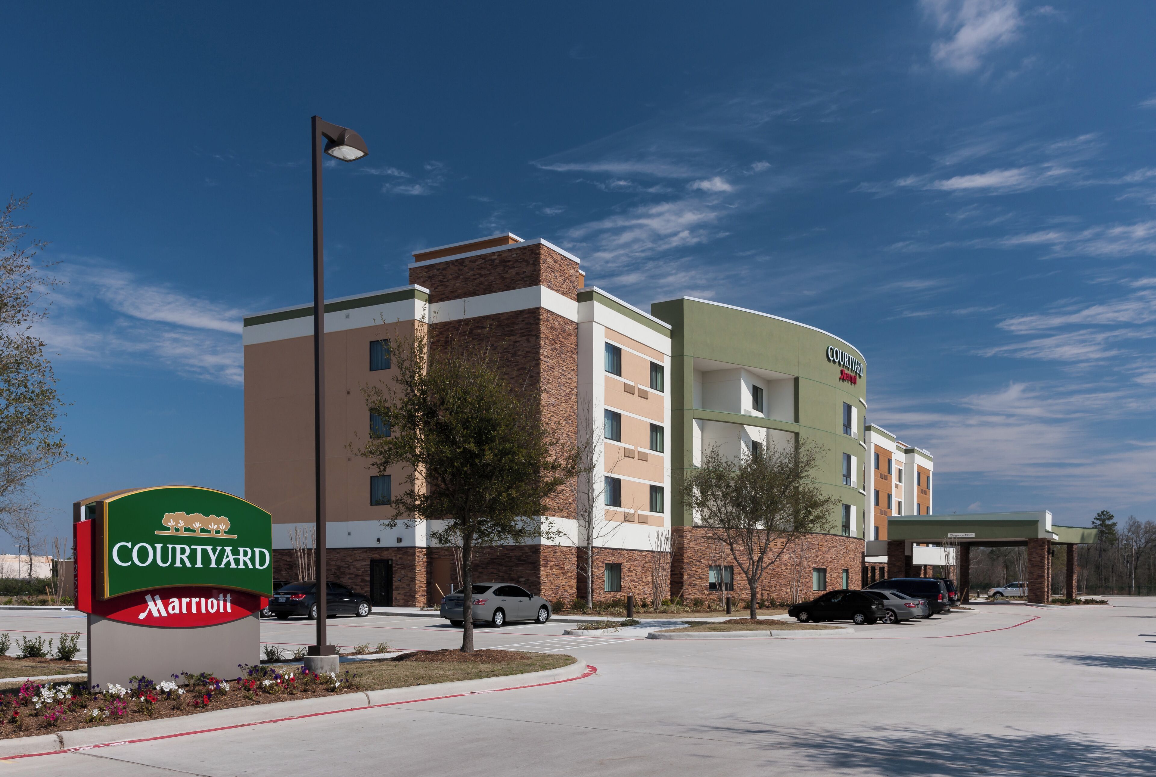 A Courtyard Marriott hotel with a brick facade, multiple floors, and a parking lot.