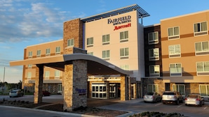 Un hôtel Fairfield Inn & Suites de la chaîne Marriott, doté d’un design moderne, avec une entrée imposante et un parking pouvant accueillir plusieurs voitures.
