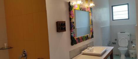 A bathroom with a sink, mirror, and toilet.