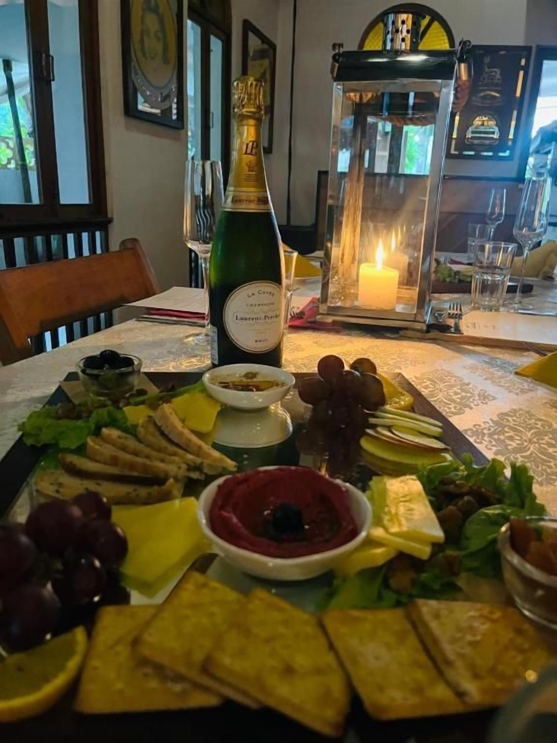 Una mesa con diversas opciones de comida y una botella de champán.