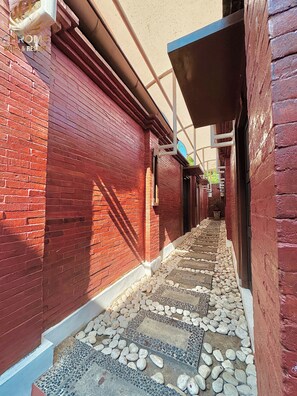 Un callejón estrecho con paredes de ladrillo rojo y un camino de adoquines.