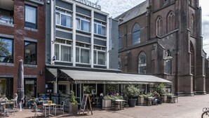 A Bavarian restaurant with outdoor seating and a sign reading "Eten & Drinken". - Hotel St. Lambert (Helmond)