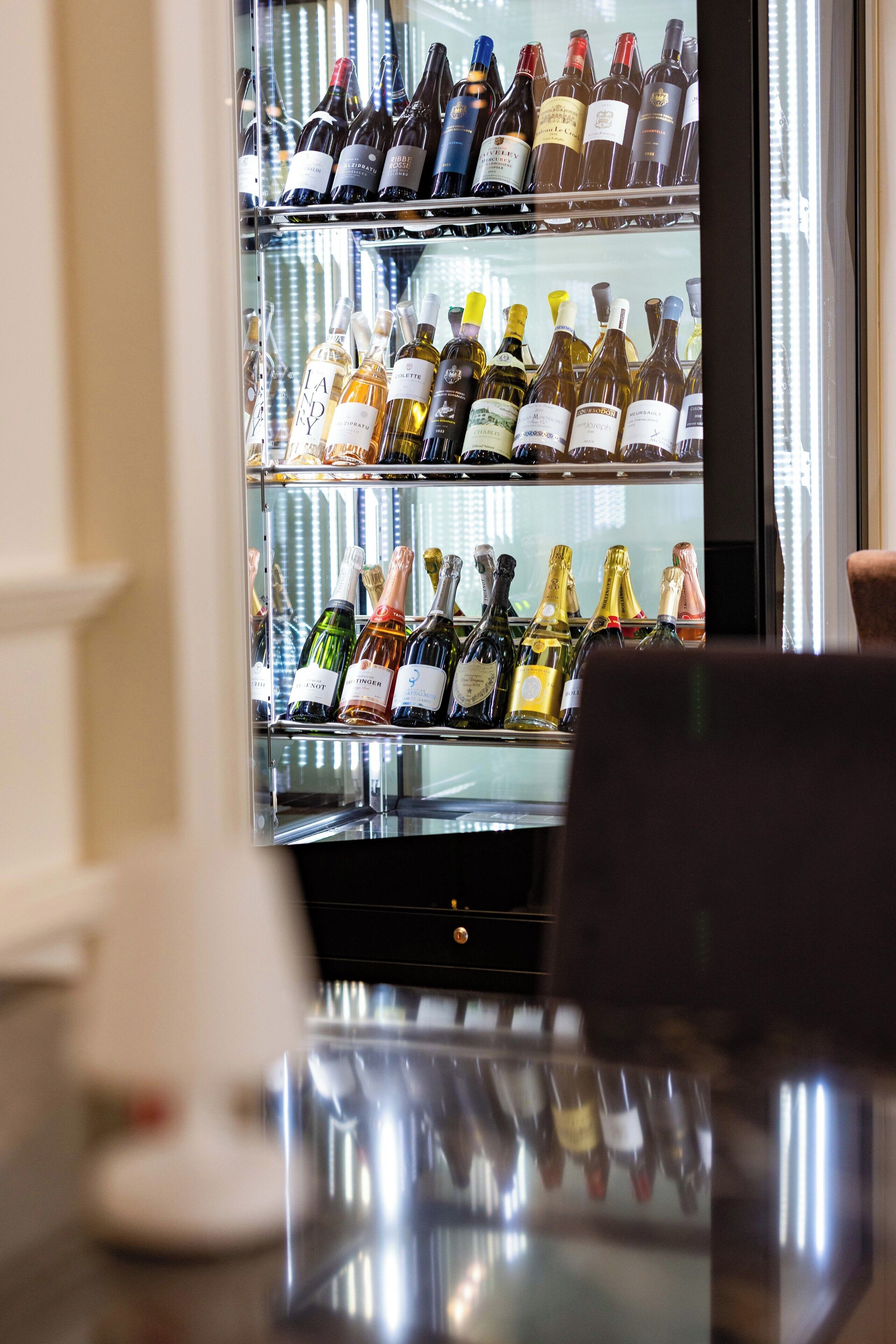 A wine refrigerator stocked with various bottles of wine.