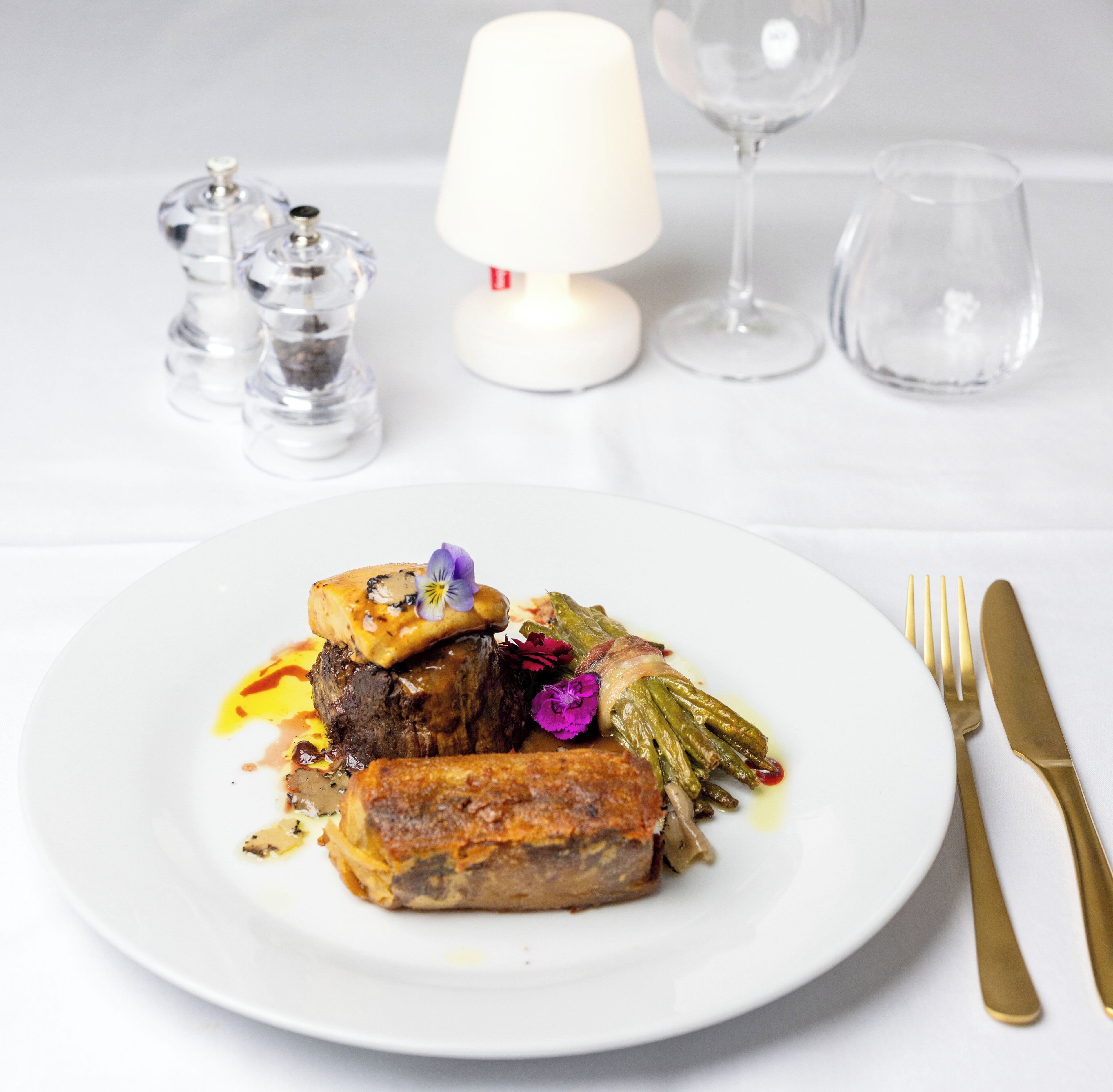 A plate of food with a fork and knife on the right.