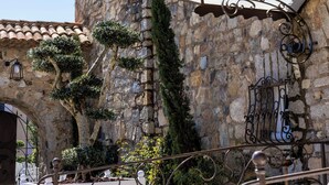 A hotel sign with a traditional design, a stone building facade, and a decorative metal awning.
