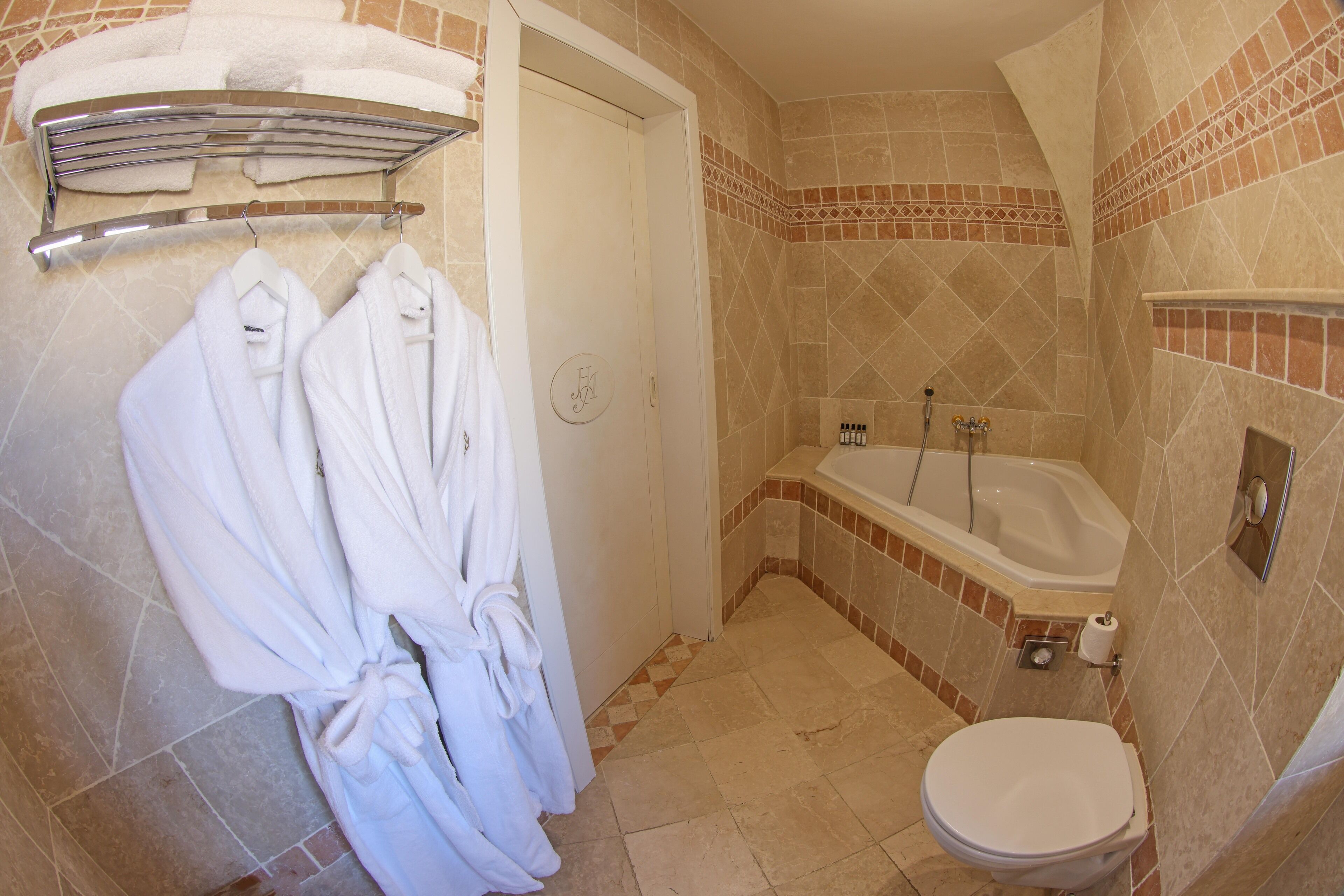 Une salle de bain avec une baignoire, des toilettes et des serviettes suspendues sur un porte-serviettes.