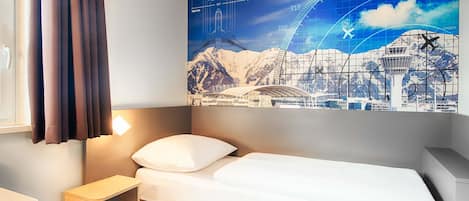 Une chambre d’hôtel avec un lit, une table de chevet, une lampe et une grande fenêtre avec des rideaux.