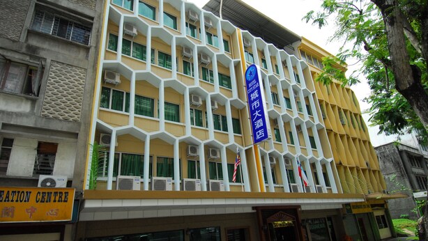 A hotel with a yellow facade, multiple air conditioning units, and a sign indicating it is a City Star Hotel. - Hotel City Star (Sandakan)