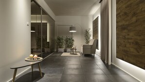 Un couloir moderne avec un banc, des plantes en pot et un canapé.