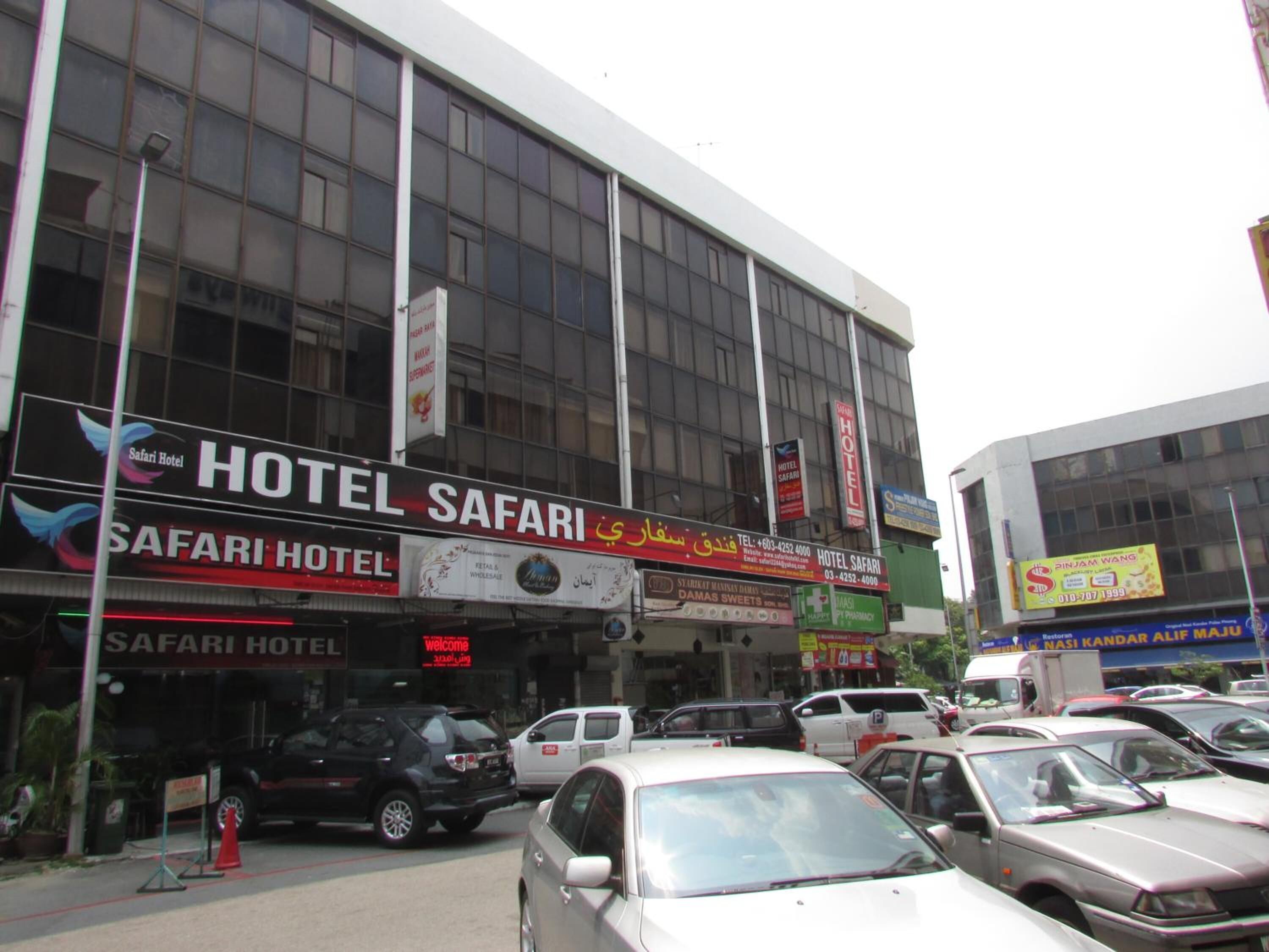 Ein Gebäude mit mehreren Schildern, die 'Hotel Safari' und 'Safari Hotel' zeigen.
