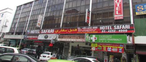A building with multiple signs for Hotel Safari, including contact information and a website.