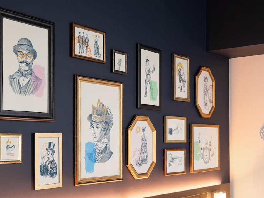 A wall with various framed artworks.