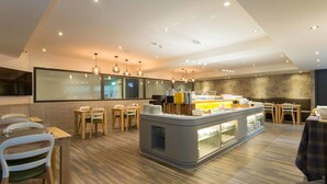 Un restaurante moderno con una barra central, mesas y sillas de madera.