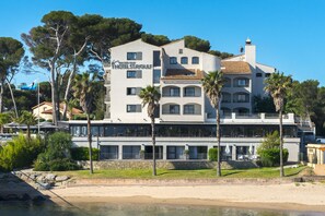 Un hôtel à plusieurs étages, doté de balcons et offrant une vue sur la plage.