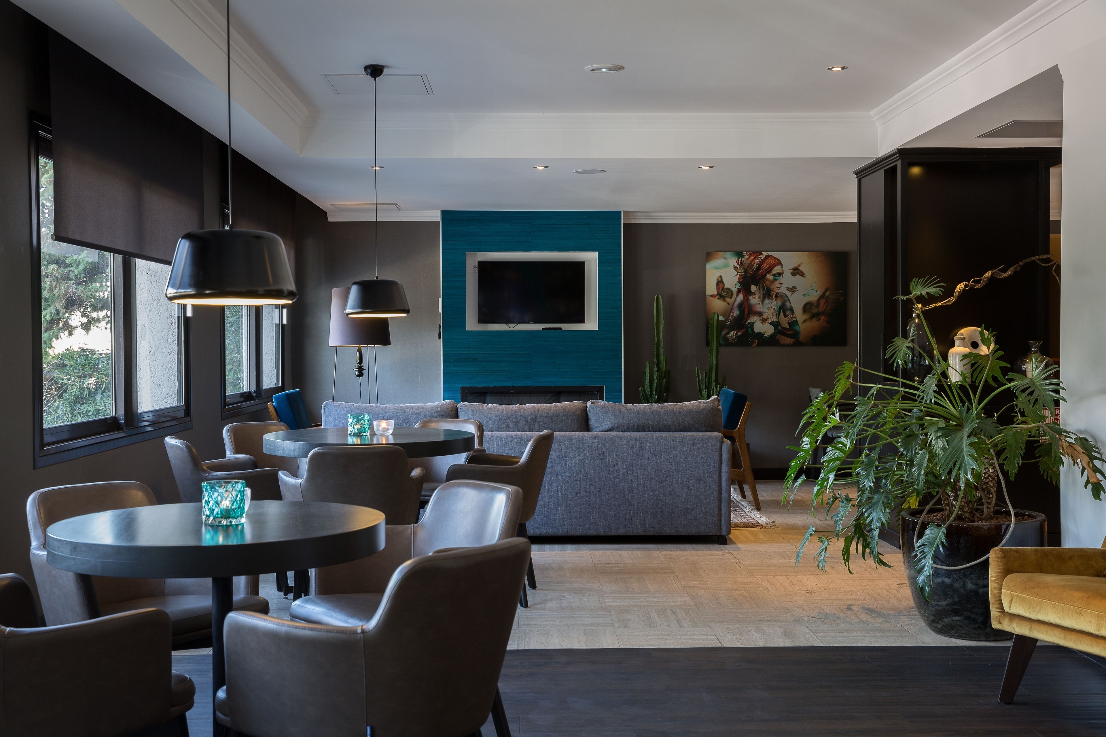 Ein modernes Wohnzimmer mit großem Fernseher, bequemen Sitzmöglichkeiten und einem Blumentopf.
