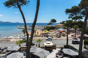 Une ville côtière dotée d’un port de plaisance, d’une plage et d’un espace extérieur aménagé avec des parasols.