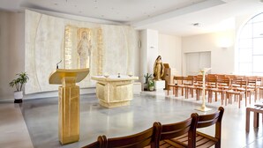 A church interior with pews, a pulpit, and a large religious statue. - Domaine Lyon Saint Joseph (Francheville)