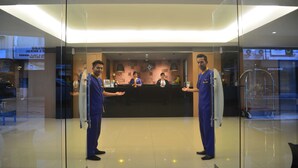 A reception area with a glass partition, a reception desk, and a security camera. - Yunna Hotel (Bandar Lampung)